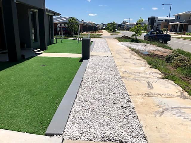 New garden bed with white pebbles beside lawn at a Throsby home